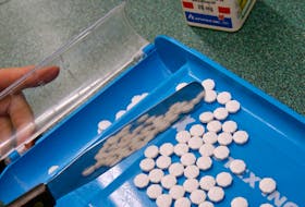 A pharmacist counts cancer treatment pills at the Family Drug Centre in Dartmouth on Friday.