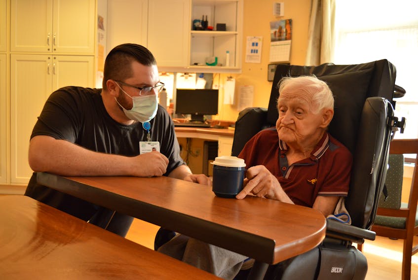 Resident care worker Kaelin Fisher helps resident Leonard Martin with a drink of water at Prince Edward Home Aug. 8. Alison Jenkins • The Guardian