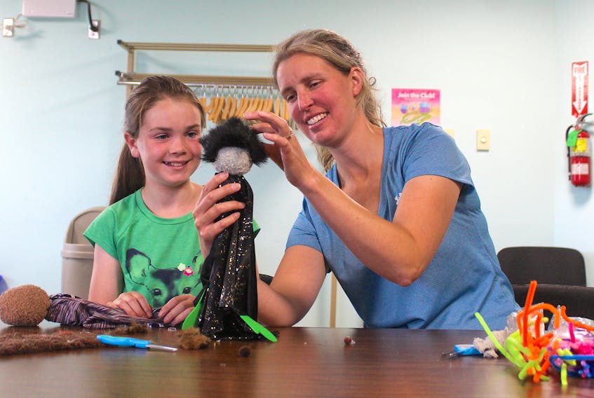 Caelyn MacLeod and her mom Amanda MacLeod work on their puppets during a workshop at the James McConnell Memorial Library in Sydney on Monday. Chris Connors/Cape Breton Post