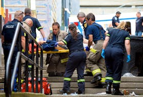 First responders tend to a male who reportedly fell from the roof of a George Street business Tuesday morning.