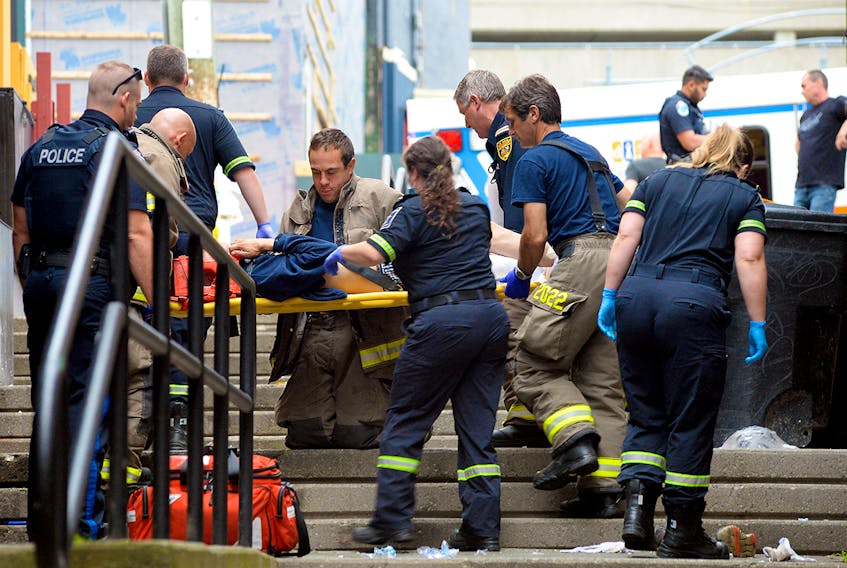 First responders tend to a male who reportedly fell from the roof of a George Street business Tuesday morning.