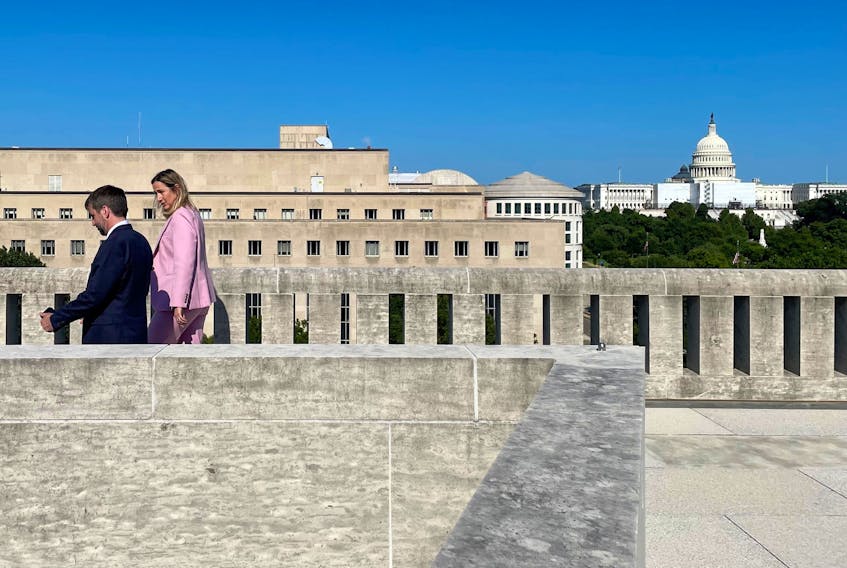 Steven Guilbeault walks alongside Canada’s ambassador to the U.S., Kristen Hillman, atop the Canadian embassy with the Capitol Building in the background. — Contributed photo