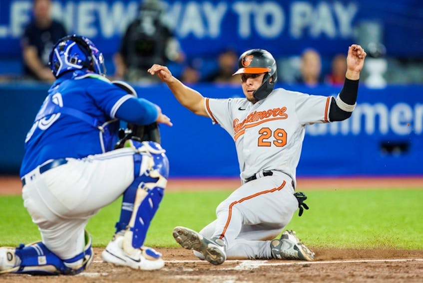 Ramon Urias of the Baltimore Orioles slides home safely to score on a Ryan McKenna single against the Blue Jays in the sixth inning on Tuesday night at the Rogers Centre.