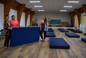 Chasity Chennell, housing support worker, left, trustee Susan Mumford, and housing support worker Amanda Denomme, place one of the mattresses that have increased the number of beds at Viola’s Place from eight to 20. Ray Burns – The News