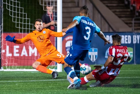 Atletico Ottawa’s Ivan Perez redirects the ball past a falling HFX Wanderers keeper Christian Oxner in front of dfeender Zachary Fernandez in stoppage time Wednesday night in Ottawa. The play was initially called offside and the goal was waved off but the call was reversed and the goal stood as the winner in an Ottawa 3-2 victory. - CANADIAN PREMIER LEAGUE