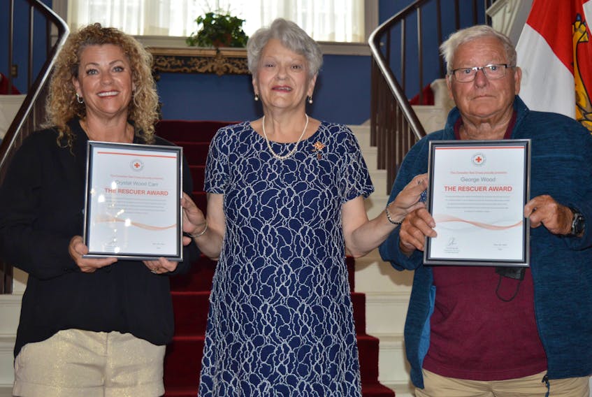 Lt.-Gov. Antoinette Perry, centre, presented Canadian Red Cross Rescuer Awards to Crystal Wood Carr, left, and her father, George Wood, on Aug. 2 at Government House in Charlottetown. Dave Stewart • The Guardian
