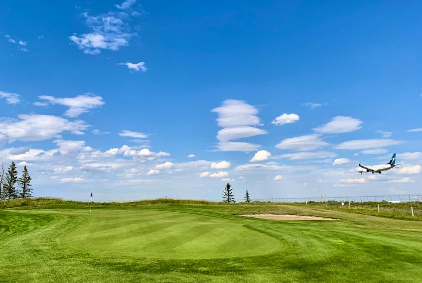 A plane lands just beyond the fifth green on the Runway Nine at Wingfield Golf Club. Located near the Calgary International Airport, the 27-hole hangout was rebranded and reopened in 2021.