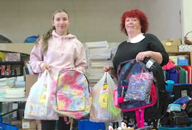 Maddie Power, left, a summer worker at the Every Woman’s Centre, and support worker Wanda Earhart are filling backpacks filled with school supplies to help parents struggling with the cost of school supplies. “This year, the price of groceries and everything else, my goodness … we’ve had moms cry because their kid was going to have to use broken crayons from last year,” said Earhart. Chris Connors/Cape Breton Post