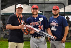 Sydney Sooners catcher Corson O’Rourke, middle, is shown with Sooner legend Scott “Ziggy” Seigfried, left, and coach Kenny Long after winning the Baseball Canada Senior Men’s National Championship home run derby at the Susan McEachern Memorial Ball Park in Sydney, Wednesday. O’Rourke was presented with a bat and an autographed jersey for winning the event by Seigfried. JEREMY FRASER/CAPE BRETON POST.