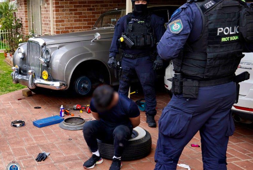  Police photographs of the raid shows the distinctive lines of a metallic silver Bentley in the driveway of a home, under an open car port.