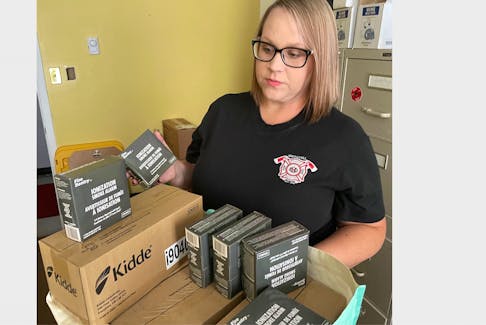 Lt. Cathy Spence of the Springhill Fire Department looks over some of the smoke detectors the firefighters association has purchased for Springhill elementary students. The association has purchased 325 smoke detectors. - Darrell Cole/Municipality of the County of Cumberland