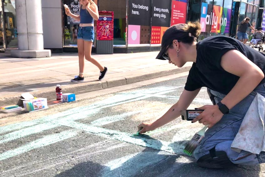 Street artist Nakita Morris recreates paintings from the Sobey family collection Saturday outside Scotiabank on Water Street,