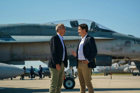 Prime Minister Justin Trudeau speaks with NATO Secretary General Jens Stoltenberg near a Canadian Forces CF-18 Hornet fighter aircraft during their visit to CFB Cold Lake in Cold Lake, Alberta, Canada August 26, 2022.  Adam Scotti/Prime Minister's Office/Handout via REUTERS