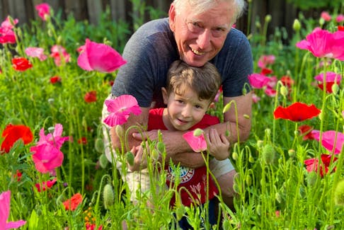 Mark Cullen and his grandson Conrad Cullen enjoy time in a garden of flowers planted to attract hummingbirds. Contributed
