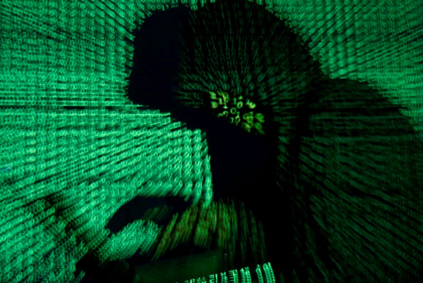 FILE PHOTO: A man holds a laptop computer as cyber code is projected on him in this illustration picture taken on May 13, 2017. REUTERS/Kacper Pempel  After a cyberattack plunged hospitals in Newfoundland and Labrador into a crisis last year, federal, provincial and territorial governments across Canada are ramping up cybersecurity for the health-care sector. -Reuters Inc. file photo