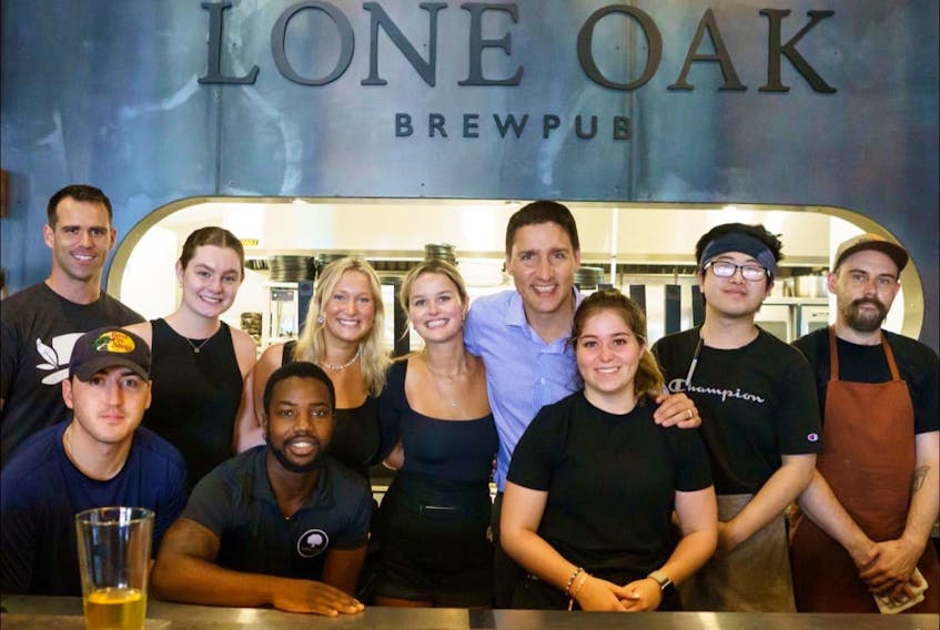 Prime Minister Justin Trudeau, fourth from the right, poses for a picture with staff members at Lone Oak Brewpub in Charlottetown on July 22. Contributed