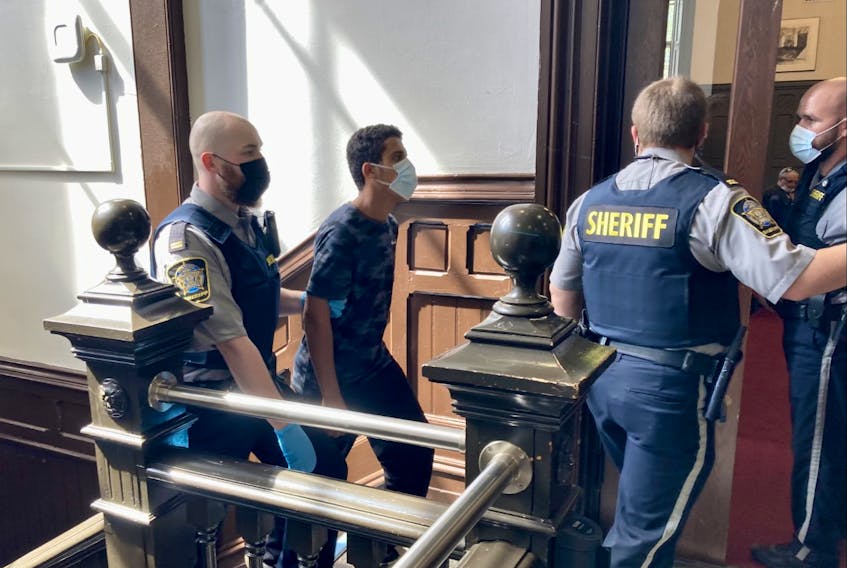 Mohammad Jamal Shned Al-Dulaimi is led into Halifax provincial court Wednesday to face six counts of sexual assault and seven of criminal harassment. His bail hearing was postponed until Sept. 7 while defence lawyer Pat Atherton puts together a release plan.