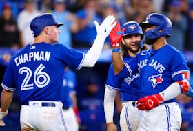Blue Jays' Matt Chapman, left, and Bo Bichette, centre, celebrate a three-run home run by Teoscar Hernandez, right, in the sixth inning against the Cubs at Rogers Centre in Toronto, Tuesday, Aug. 30, 2022.
