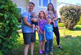 Angie AuCoin, left, and wife Amber AuCoin, stand with their children outside their Sydney home the morning of July 24. The couple were married in a small ceremony on their back patio on May 21, 2021 and welcomed their twins in April. Angie is holding Loïc AuCoin and Amber is holding Lexi AuCoin. In between them in front is Carson McVicar, 5, and his sister Georgia McVicar, 7. NICOLE SULLIVAN/CAPE BRETON POST