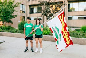 R.J. Hetherington, left, and Vanessa Keefe pose with a Prince Edward Island flag. Hetherington and Keefe, members of the Team P.E.I. wrestling team, have been selected as flag-bearers for the opening ceremonies of the 2022 Canada Summer Games in St. Catharines, Ont., on Aug. 6. Photo Courtesy of P.E.I. Canada Games