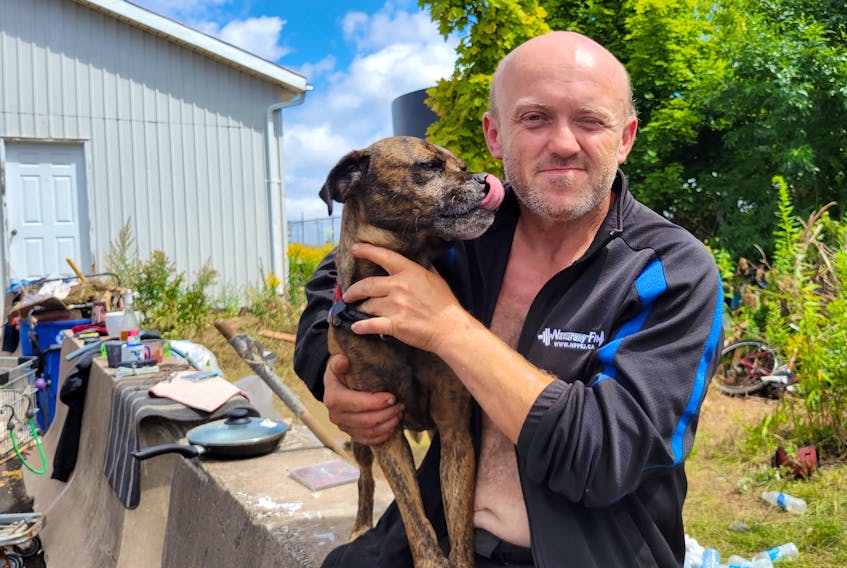 Steve Wott, a resident of the downtown tent city in Charlottetown, holds his dog, Nova. Wott says he has been homeless since the winter, and had difficulty finding housing because few landlords allow dogs, especially in smaller apartments. - Logan MacLean • The Guardian