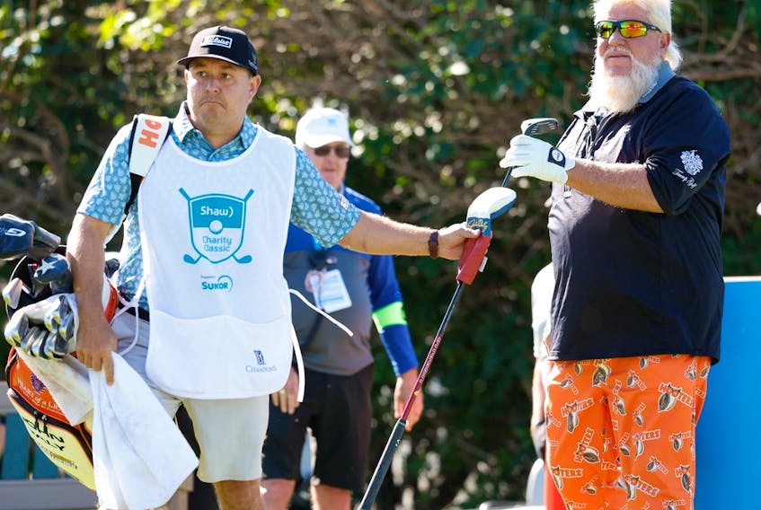 Matt Freeman, head pro at Canyon Meadows Golf and Country Club, caddies for John Daly during the Shaw Charity Classic at Canyon Meadows in Calgary on Friday, Aug. 5, 2022. 