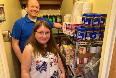 Rev. Michael Koslowski, Calvin Presbyterian Church minister, and Allison Power, mission outreach team leader, display some of the grocery items they're providing to the Fairview community. 