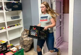 Hailey Parsons had a busy day Monday, Aug. 8, at the Vape Falls shop she manages, hastily storing product in crates to allow a quick removal should the forest fires near Grand Falls-Windsor threaten the business. RANDY EDISON PHOTO