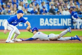 Zach McKinstry of the Cubs slides into third for a triple as Blue Jays third baseman Matt Chapman awaits the throw in the third inning at the Rogers Centre in Toronto, Wednesday, Aug. 31, 2022.