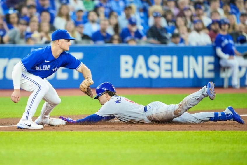 Zach McKinstry of the Cubs slides into third for a triple as Blue Jays third baseman Matt Chapman awaits the throw in the third inning at the Rogers Centre in Toronto, Wednesday, Aug. 31, 2022.