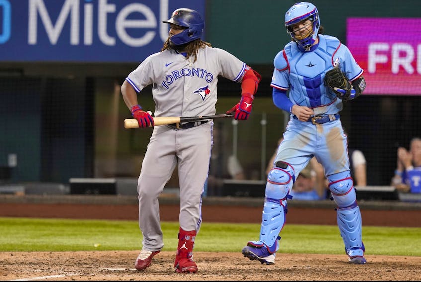 Blue Jays' Vladimir Guerrero Jr., left, and Texas Rangers catcher Jonah Heim react after the final strike ending the baseball game in Arlington, Texas, on Sunday, Sept. 11, 2022. 