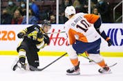  Sarnia Sting’s Max Namestnikov follows through on a shot while being defended by Flint Firebirds’ Simon Slavicek in the first period at Progressive Auto Sales Arena in Sarnia, Ont., on Monday, Feb. 21, 2022.