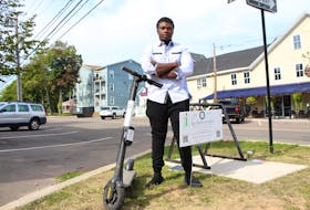 Tafadzwa Mpaso, owner of Epic Electrical Scooters, stands with one of his e-scooters on the corner of Kent Street and Prince Street in Charlottetown on Sept. 12. Rafe Wright • The Guardian
