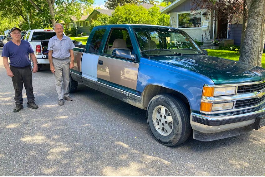 Neigbhours Clark Shanks, left, and Mark Soehner with the 1995 Chevy Silverado. Soehner drove the truck close to 360,000 kilometres before he parked it in 2017 and then sold it in 2021 to Shanks, who tended to the mechanical systems and is now repairing the body Contributed/Mark Soehner