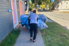 Robert Stewart walks with a cartload of recyclables on LeMarchant Street in Halifax on Saturday afternoon.