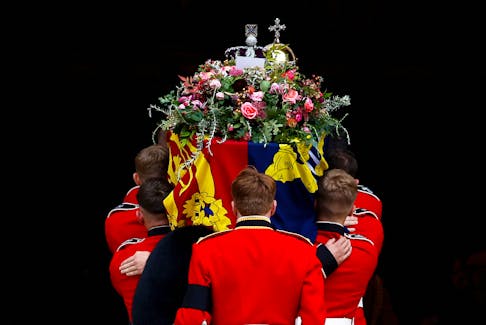 Pallbearers carry the coffin of Queen Elizabeth II with the Imperial State Crown resting on top into St. George's Chapel on Monday, Sept. 19, 2022 in Windsor, England. The committal service at St George's Chapel in Windsor Castle took place after the state funeral at Westminster Abbey. - Jeff J Mitchell / Pool via Reuters