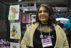Hailee McDonald, who uses the artist name Tsekwichoghart, stands beside her booth at CaperCon 2022 in Sydney. Behind her are some of her Indigenous mermaids which are McDonald's original designs. NICOLE SULLIVAN / CAPE BRETON POST