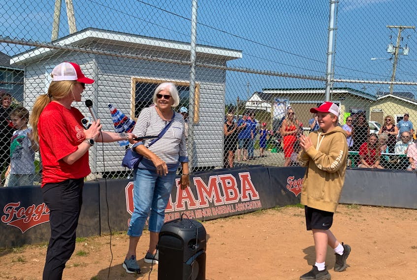 CHAMBA U13 player Ethan Nickerson (from right) walks up to receive the Matt Maxwell Award for his division from June Maxwell and CHAMBA president Karen Stoddard. KATHY JOHNSON