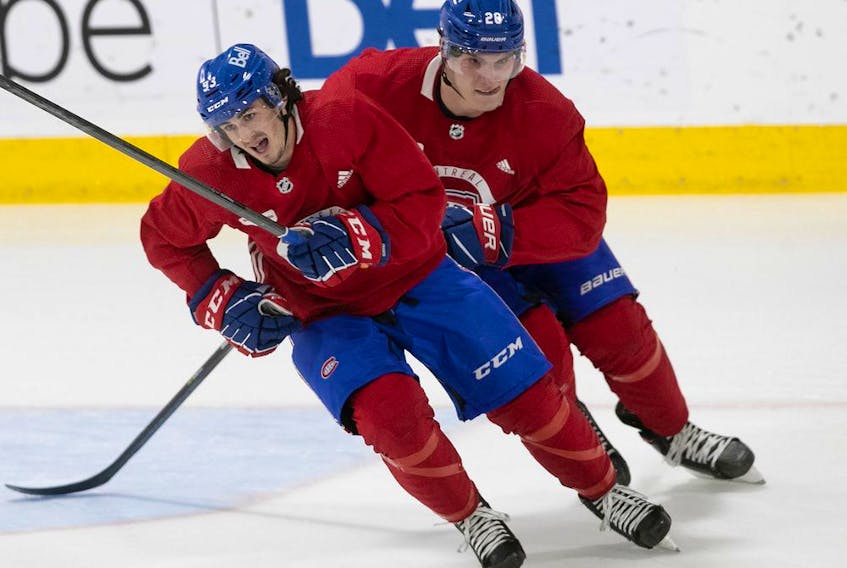 Montreal Canadiens' Juraj Slafkovsky, rear, goes through drill with Ryan Francis during first day of training camp in Brossard on Sept. 22, 2022.
