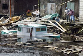FOR JUAN STORIES:
Fishermen attept to reassemble their shattered wharf while trying to get to their fishing boat, Secondwind, in Herring Cove, following Hurricaine Juan, Monday. 

Photo by Tim Krochak