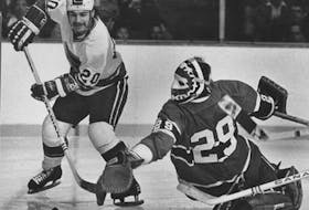 Bobby Lalonde of the Vancouver Canucks attempts to get a puck past Montreal Canadiens goalie Ken Dryden during a National Hockey League playoff game in 1975. In his new book, Dryden said the 1972 Summit Series revolutionized hockey. 