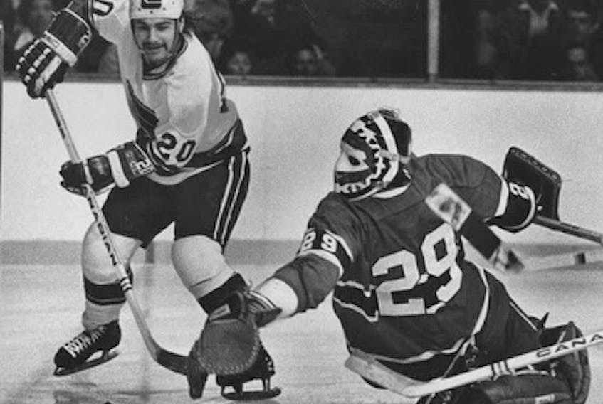Bobby Lalonde of the Vancouver Canucks attempts to get a puck past Montreal Canadiens goalie Ken Dryden during a National Hockey League playoff game in 1975. In his new book, Dryden said the 1972 Summit Series revolutionized hockey. 