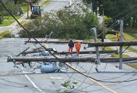 Nova Scotia Power employees walk down a stretch of Woodlawn Road in Dartmouth that was heavily damaged during hurricane Fiona on Saturday, Sept. 24, 2022. Ryan Taplin - The Chronicle Herald
