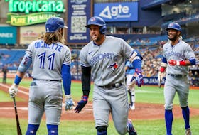 Bo Bichette of the Toronto Blue Jays congratulates George Springer on his third-inning home run that also scored Raimel Tapia (right) against the Tampa Bay Rays at Tropicana Field on September 25, 2022 in St. Petersburg, Florida. 