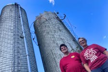 David and Denise Bekkers stand in front of a damaged silo at their farm in Lanark, Antigonish County.