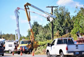 Crews work on a power line on Crowes Mills Road Sunday afternoon.