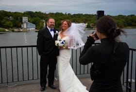Mark Weeks and Jolene Rudolph have wedding photos taken on the balcony of the Mic Mac Aquatic Club in Dartmouth on Saturday. The Eastern Shore couple got married despite post-tropical storm Fiona.