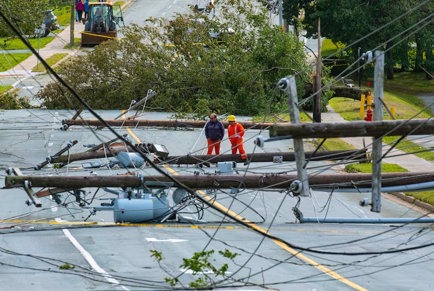 Nova Scotia Power employees check out downed lines on Woodlawn Road in Dartmouth on Saturday.