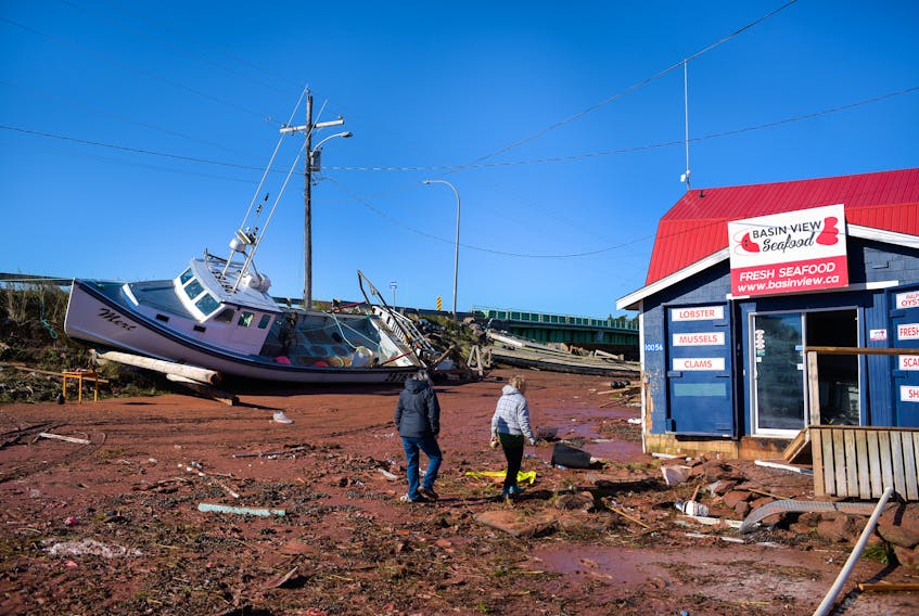 Kathy Brown and Barb Doiron assess the damage in Stanley Bridge on Sept. 25 following post-tropical storm Fiona. Doiron, who owns Bay View Antiques, said the storm was the worst she's ever seen. Nathan Rochford • Special to The Guardian
