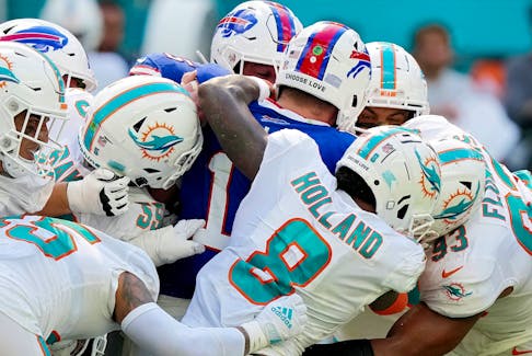 Josh Allen  of the Buffalo Bills is gang-tackled by the Miami Dolphins defence during the fourth quarter at Hard Rock Stadium on September 25, 2022 in Miami Gardens, Florida. 